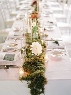 a long table with candles and flowers on it