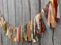 an old cloth garland hanging on the side of a wooden fence