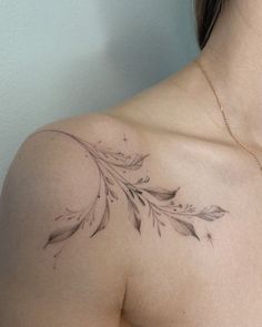 a woman's chest with a leaf tattoo on her left shoulder and right breast