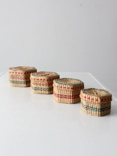 four small baskets sitting on top of a white table