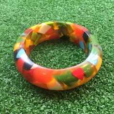 "1930s End Of The Day Confetti Lucite Multicolour Bangle. This vibrant and stunning piece  one of the most remarkable we have found.  Undeniably unique,  the bangle has weight and substance  A beautiful mix of bright colours  and is in outstanding vintage condition.  The wearable diameter is 2 1/2 inches,  The complete piece is 3 1/2 inches diameter.  The bangle measure 7/8 of an inch wide . This is a great collectible bangle. Would make a great gift . A true One Off!  Developed in the 1930s, th Retro Handmade Bangle Jewelry, Retro Multicolor Bracelet Jewelry, Retro Multicolor Round Jewelry, Multicolor Round Retro Jewelry, Handmade Retro Bangle Bracelet, Retro Multicolor Bracelets For Gift, Multicolor Retro Bracelets For Gift, Multicolor Retro Bracelet For Gift, Vintage Multicolor Bracelets