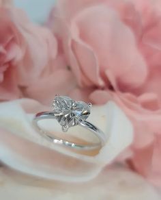 a diamond ring sitting on top of a flower