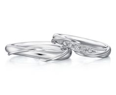 two white gold wedding rings with diamonds on top and one diamond in the middle, sitting side by side