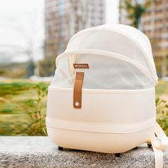 a white backpack sitting on top of a cement bench