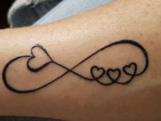 a couple of hearts are in the shape of an infinite love knot on someone's arm