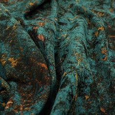 the fabric is green and brown with yellow spots on it's surface, as well as rusted edges