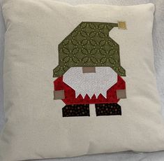 a white pillow with a patchwork gnome on it