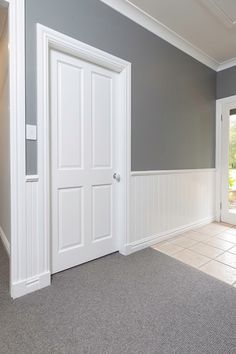 an empty room with gray walls and white trim on the door, carpeted floor