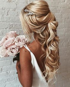 a woman with long blonde hair and flowers in her hair, wearing a white dress