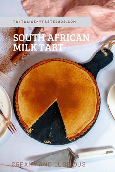 a pie sitting on top of a white table next to plates and utensils