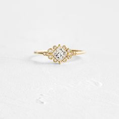 a gold ring with a white diamond in the center and two small diamonds on each side