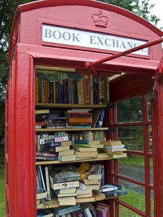 a red phone booth with books in it