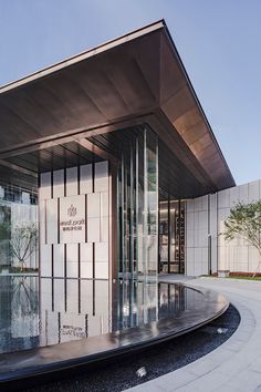 the entrance to an office building with large glass doors and circular fountain in front of it