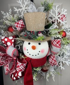 a christmas wreath with a snowman wearing a top hat and bow tie on the front door