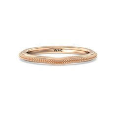 a rose gold wedding band with the word w c engraved on it's side