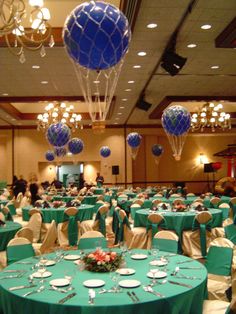 a banquet hall with tables and chairs covered in green tablecloths