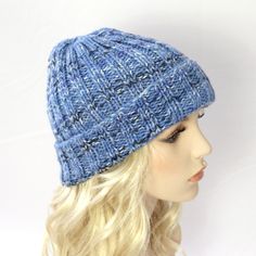 a mannequin head wearing a blue knitted hat on top of a wig