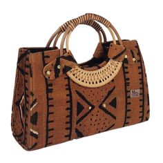 Introducing the Nasika Tote, a stunning handbag crafted from rich mudcloth. This traditional Malian fabric is renowned for its unique texture and cultural significance, making each bag a wearable piece of art. The intricate patterns and earthy tones of the mudcloth create a sophisticated look that's both elegant and eye-catching. With its spacious interior, sturdy cane handles, and inner pocket, this bag is as functional as it is beautiful. Every purchase supports women from low-income weaving c Brown Handheld Canvas Bag, Traditional Top Handle Bag In Natural Color, Traditional Top Handle Shoulder Bag In Natural Color, Brown Rectangular Jute Shoulder Bag, Traditional Natural Color Top Handle Shoulder Bag, Traditional Natural Color Top Handle Bag, Traditional Natural Top Handle Shoulder Bag, Eco-friendly Brown Handheld Bag, Eco-friendly Handheld Brown Bag