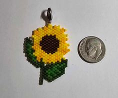 This is a hand beaded sunflower, by me. Made with small beads and thread. It has a little clasp so it can be attached to just about anything.  Pattern by Amazing Brick Stitch Sunflower Beaded Earrings, Beaded Sunflower Earrings, Beaded Sunflower, Beaded Sunflower Earrings Pattern, Brick Stitch Sunflower Earrings, Brick Stitch Sunflower, Flower Brick Stitch, Sunflower Earrings, Beaded Earrings Patterns