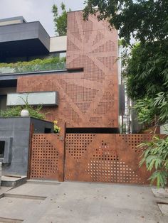 a building that has a large metal gate in front of it and some plants growing on the side