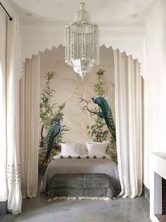 a bedroom with two peacocks on the wall and a chandelier hanging from the ceiling