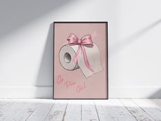 a pink poster with a roll of toilet paper tied to it's side in front of a white wall