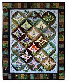 a quilted wall hanging with flowers and leaves on the front, in shades of blue