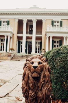 a statue of a lion in front of a large building