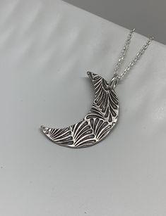 This unique silver moon necklace has been entirely handmade using .999 fine silver. It has been cut from fine silver precious metal clay, textured, fired and oxidized. The pendant hangs from a sterling silver diamond cut cable chain. This fine silver pendant features an embossed feathery leaf print pattern and hangs 1 1/4 from top of ring to bottom of the moon shape. Pendant size: approximately 1 x 3/4 inches Chain length: adjustable at 16 and 18 inches can also be customized to whatever length Silver Moon Necklace, Moon Necklace Silver, Leaf Print Pattern, Precious Metal Clay, Moon Shape, Silver Jewels, Leaf Jewelry, Bohemian Necklace, Silver Moon