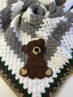 a crocheted blanket with a teddy bear on it