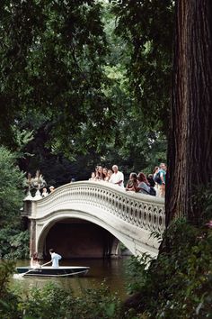 people are riding on a bridge over a river while others watch from the other side