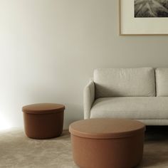 a living room with a couch, ottoman and coffee table in front of a painting on the wall