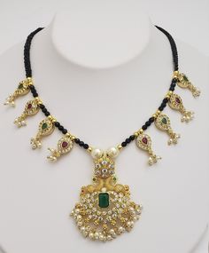 Mangalsutra is importance in Hindu culture and traditions. It is an ornament (more specifically a necklace) worn by women to signify marital status. .. Therefore, the groom tying the Mangalsutra around the bride's neck during the wedding rituals is considered a sacred Hindu custom. The white-red and white-green cz stones in this safa black beads necklace set are unique and beautiful. Superior quality stones make this sophisticated Indian jewelry a must-have. Each piece is handcrafted and made to Hindu Culture, Groom Ties, Indian Necklace, Wedding Rituals, Black Bead Necklace, Antique Pendant, Indian Wedding Jewelry, Cz Pendant, Emerald Stone