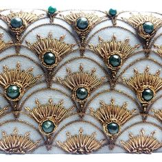 an intricately designed clutch bag with gold and green beads on it's side