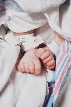 a baby wrapped up in a blanket with a tag on it's chest and feet