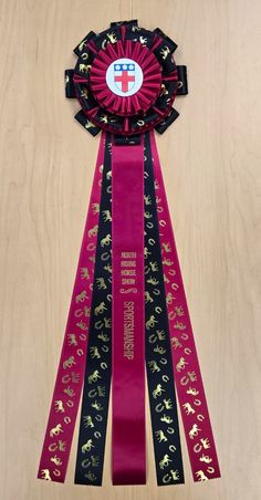 a pink ribbon with gold horses on it