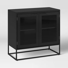 a black cabinet with glass doors and metal legs