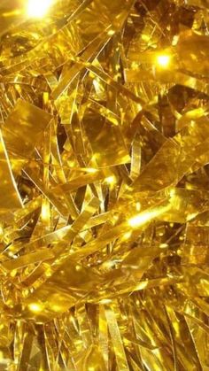 the light shines brightly on some shiny gold foiled glass shards in this image