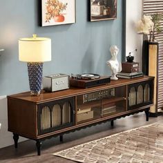 an entertainment center in a living room with blue walls and pictures on the wall above it