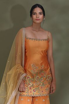 Dance the night away at weddings in this beautiful orange embroidered sharara suit. It comes with a matching dupatta. Shop designer suits in USA from Pure Elegance. DISCLAIMER: The actual product may vary slightly from the image. These are custom orders, hence expect slight variation in color and placement of the motif or buta. ESTIMATED DELIVERY: Because this is a custom order, it would take about 4 weeks from the date of purchase. RETURN POLICY: This product is a custom order and cannot be returned or exchanged. Party Orange Dupatta With Dori Work, Designer Orange Embroidered Salwar Kameez, Orange Art Silk Salwar Kameez For Wedding, Designer Orange Salwar Kameez With Intricate Embroidery, Orange Traditional Wear With Intricate Embroidery For Designer Wear, Wedding Orange Art Silk Salwar Kameez, Orange Dori Work Dress For Wedding, Orange Sharara With Resham Embroidery In Traditional Drape, Orange Anarkali Set With Dori Work For Party