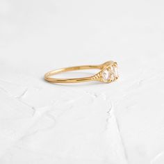 a yellow gold ring with an oval shaped diamond