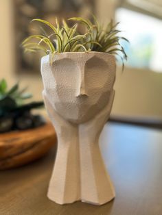 a ceramic planter sitting on top of a wooden table