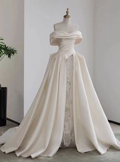 a white wedding dress on display in a room