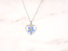 "A simple yet gorgeous everyday piece small wire heart sliding freely along on a delicate silver chain. Great for layering with other delicate necklaces or minimalist wear. Heart silver-tone bezel frame nickel and lead-free - measures about 9/16\"x 1/2\" (14x13 mm), comes with 16\" Hypoallergenic surgical steel chain or Sterling silver chain Each piece is handmade from real pressed flowers. Your design may vary slightly from the picture as each piece is one of a kind! Please keep from extreme mo Lucky Charm Necklace, Four Leaf Clover Necklace, Pressed Flower Necklace, Heart Shaped Necklace, Clover Necklace, Steel Chain, Forget Me Not, Flower Heart, Delicate Necklace