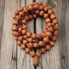 "📿Tulsi Mala handcrafted with Brown Tulsi beads. Suspended in the center is the engraved \"Krishna & Radha\" Guru Bead. When someone wears the tulsi mala, around your neck or around your wrist, you feel protected and focussed. It actually goes a long way in helping you deal with the stress of modern life.📿 🚪 Dimensions ( Approximately ) 🚪 📏Bead size: 11 MM - 12 MM 📏No. of beads: 108 Mala Bead + 1 Guru Bead 📏Mala Necklace Length: 50.0 - 51.0 inches 🚪 Pure Tulsi Beads Sourced from Vrindava Meditation Jewelry With Wooden Round Beads, Meditation Jewelry With Round Wooden Beads, Wooden Beads Jewelry For Meditation, Artisan Wooden Beads Bracelet For Meditation, Bohemian Mala With Large Beads For Meditation, Holistic Mala With Round Beads For Festival, Artisan 108 Beads For Meditation, Holistic Mala For Festival With Round Beads, Holistic Festival Mala With Round Beads