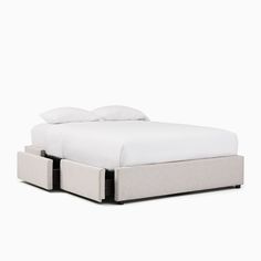 a white bed with two drawers underneath it