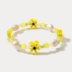 This charming Pearl Yellow Flower Beaded Bracelet adds a touch of sunshine to your wrist. Made with 18k gold-plated brass beads, it features a delicate flower design made with sparkling crystals and freshwater pearls.  Natural stone and quartz beads add a touch of organic beauty, while the stretchy elastic thread ensures a comfortable fit. This crystal bead bracelet is a delightful way to add a touch of summer radiance to any outfit. DETAILS Plating: 18K Gold Materials: 18K Gold on Brass, Pearl, Natural Stone, Quartz, Crystal, Elastic Thread Measurements: Length: 6.69 "(17cm) - 9.84"(25cm)  (Stretchable) Bead Size: 0.39"* 0.51 "(1.0cm*1.3cm) Weight: 9.2 g Flower Beaded Bracelet, Crystal Bead Bracelet, Everyday Wear Jewelry, Fruit Jewelry, Nature Earrings, Jewelry Lockets, Nature Necklace, Elastic Thread, Brass Beads