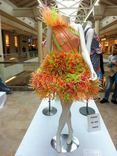 there is a mannequin wearing a colorful dress made out of plastic straws