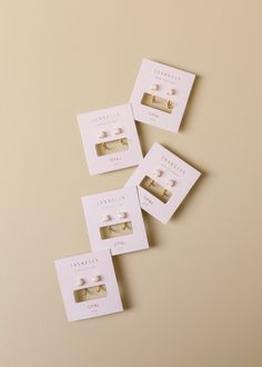 four pairs of earrings are displayed on a card