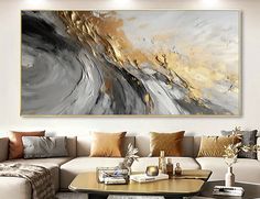 a living room filled with furniture and a large painting on the wall above it's coffee table